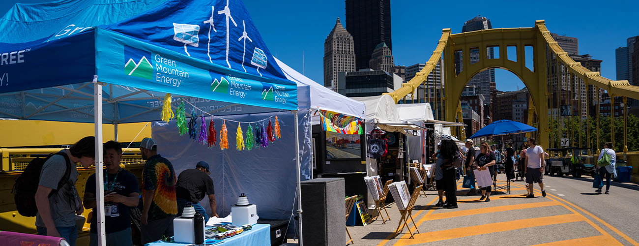 A marketing tent for Green Mountain Energy on a yellow bridge.