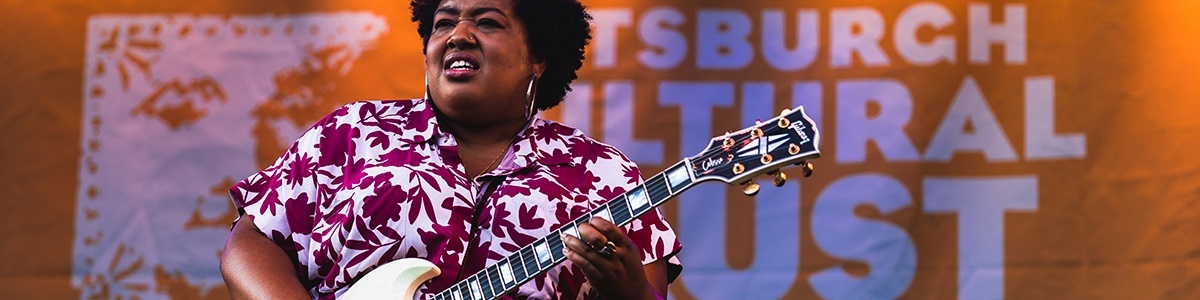 an artist on stage playing a white electric